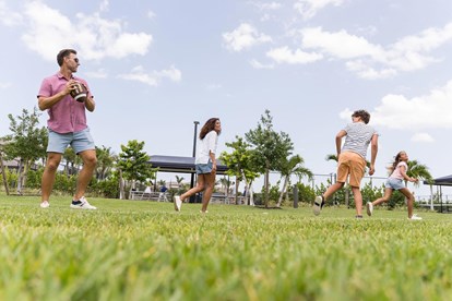 Family playing football outside Clubhouse